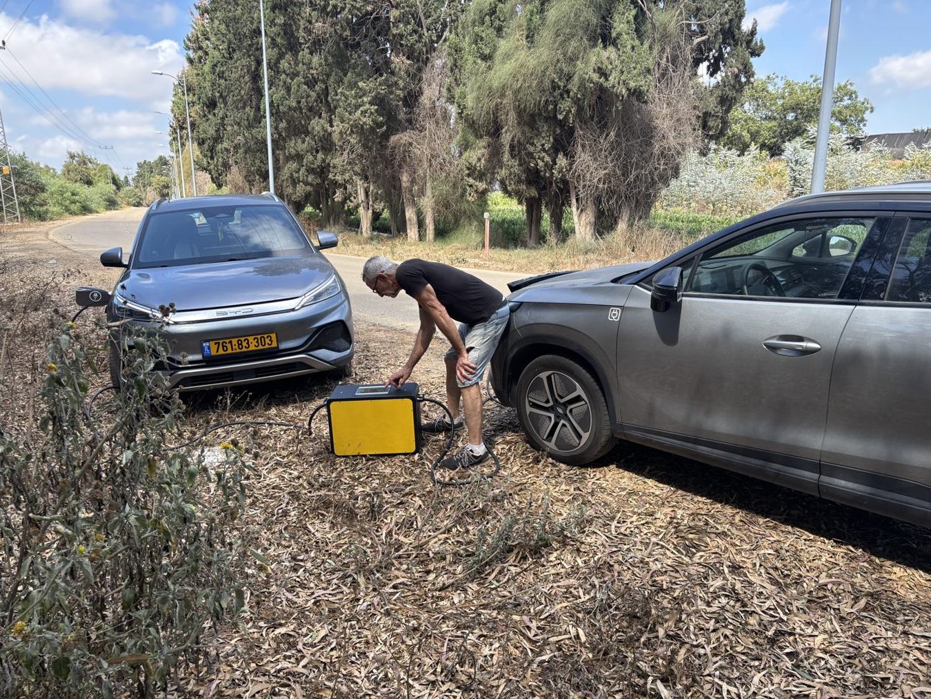 צוות טעי-נע מטעין שני רכבים חשמליים בצד הדרך